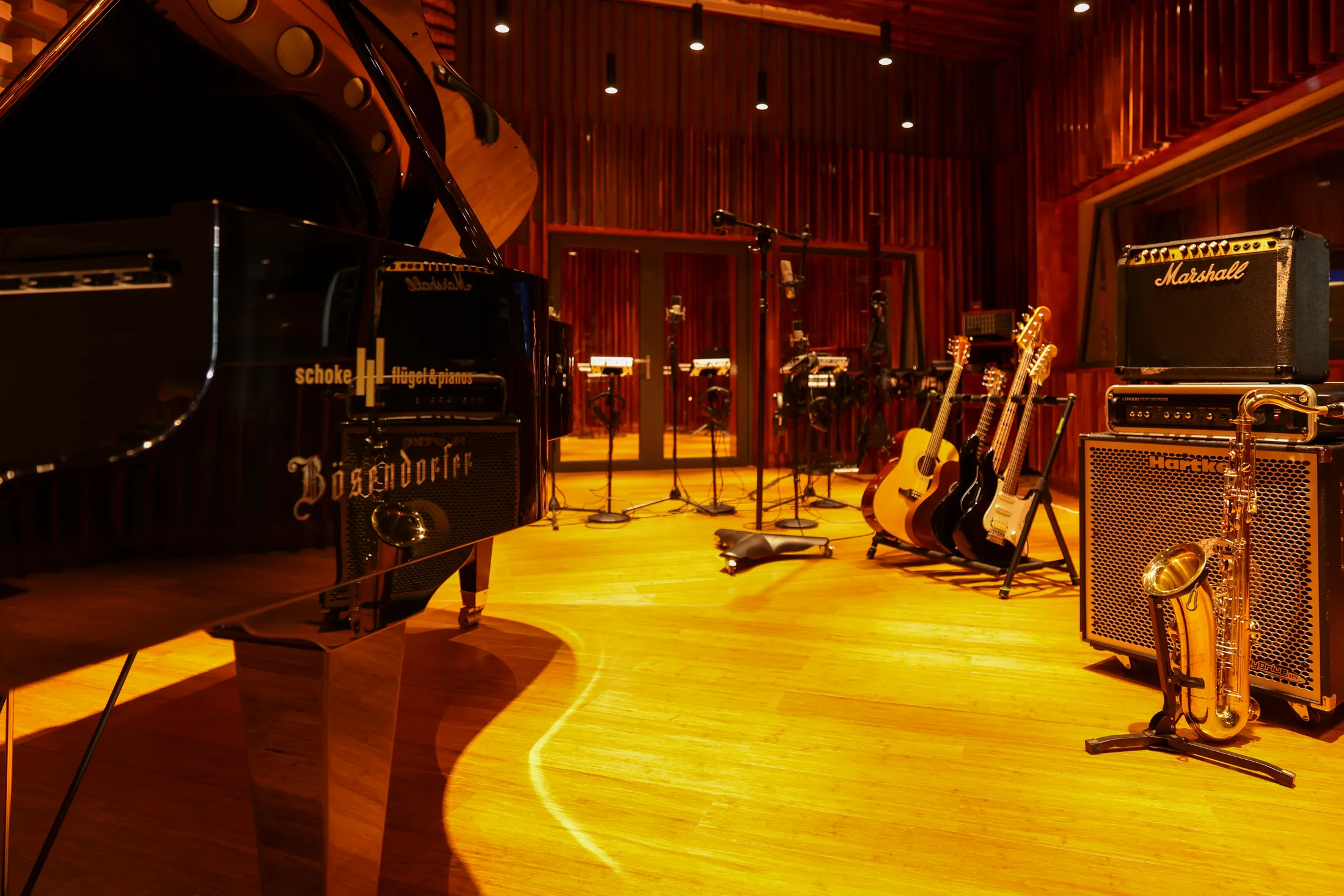 The live room — a Bösendorfer grand piano, guitars and amps ready on the warm wooden floor